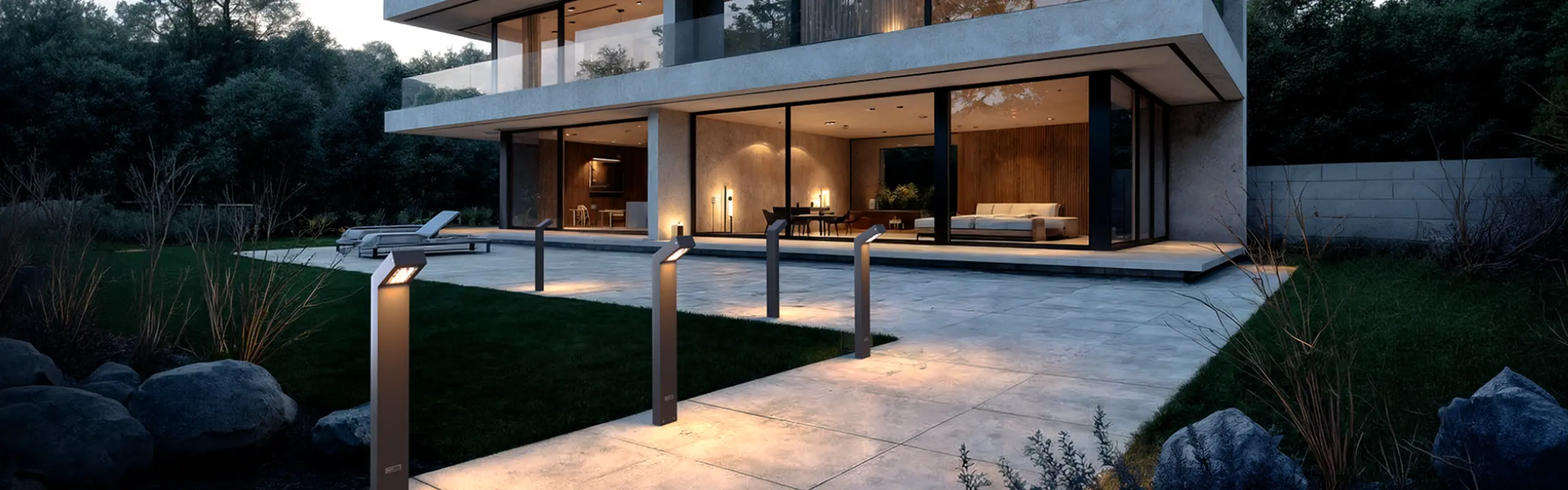 A row of Fonelight bollard lights lining a poolside path at a modern home at dusk