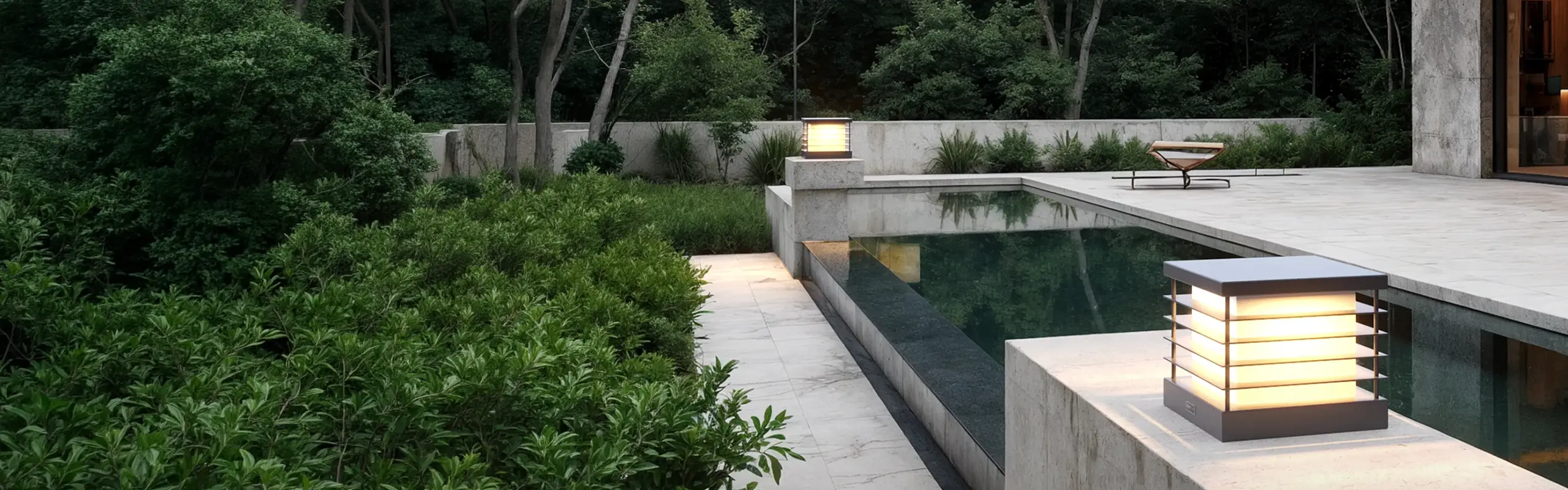 Fonelight pillar-mounted lights along a pool edge at a modern home in the evening