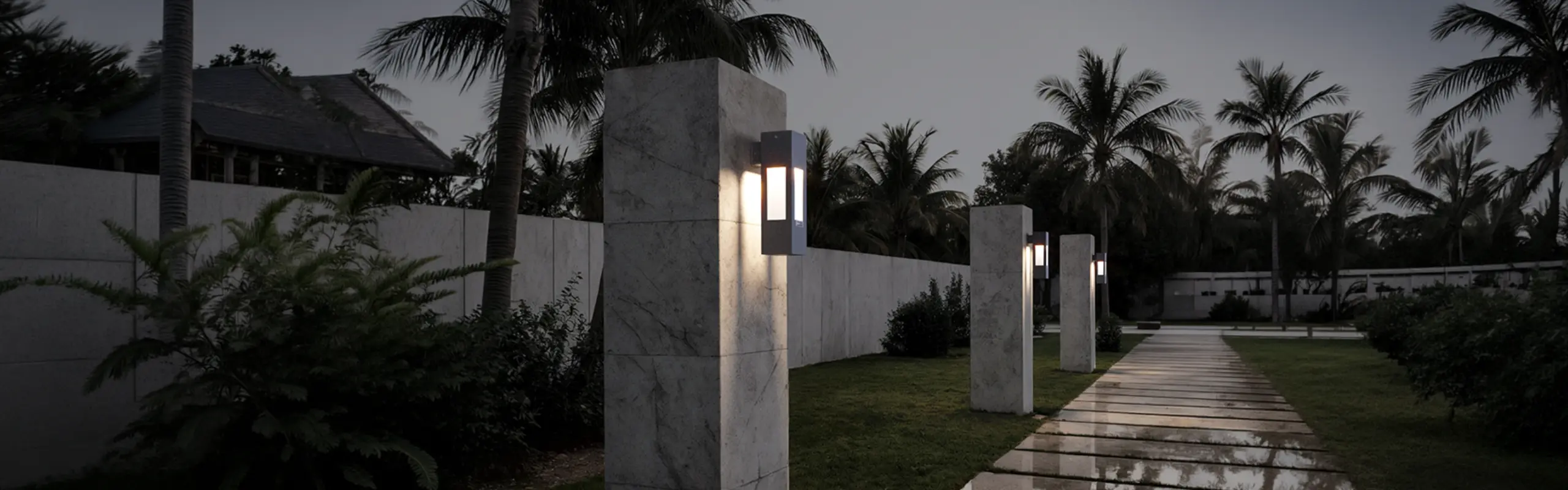 Fonelight wall sconces mounted on stone entrance pillars along a garden path at dusk