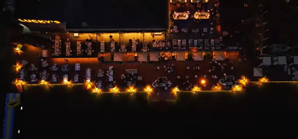 Aerial night view of the same beachfront deck fully lit end to end